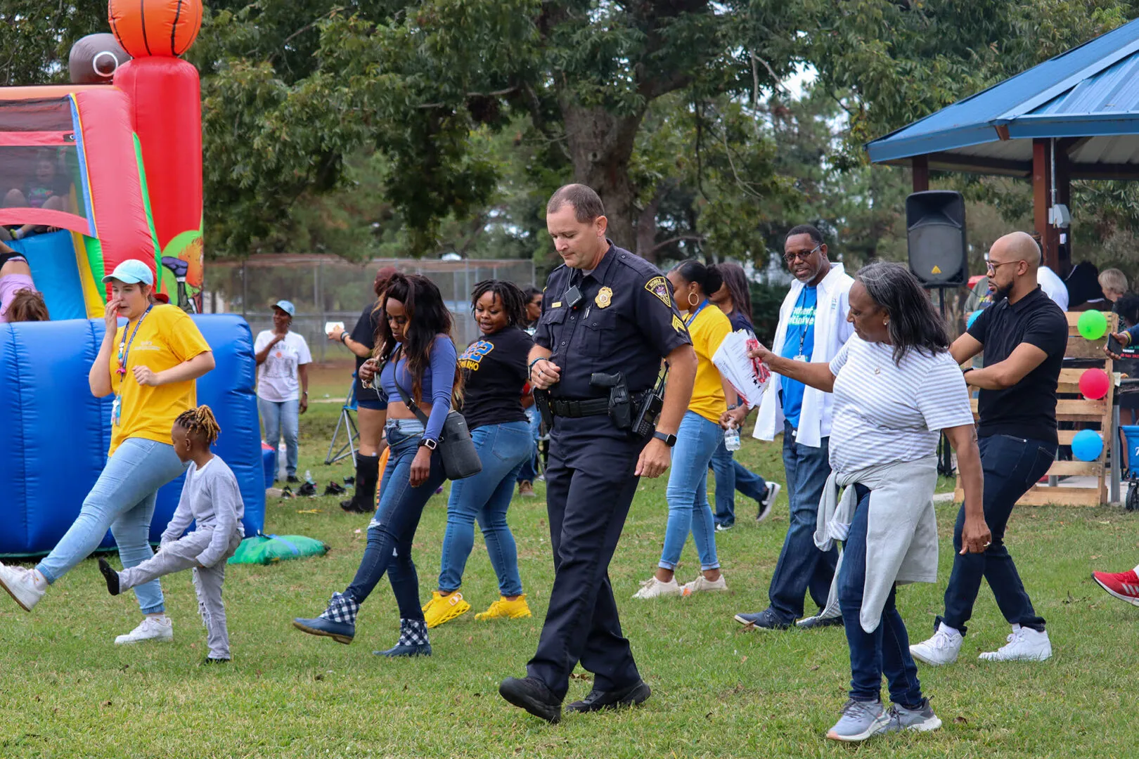 a police officer walking through a park with children